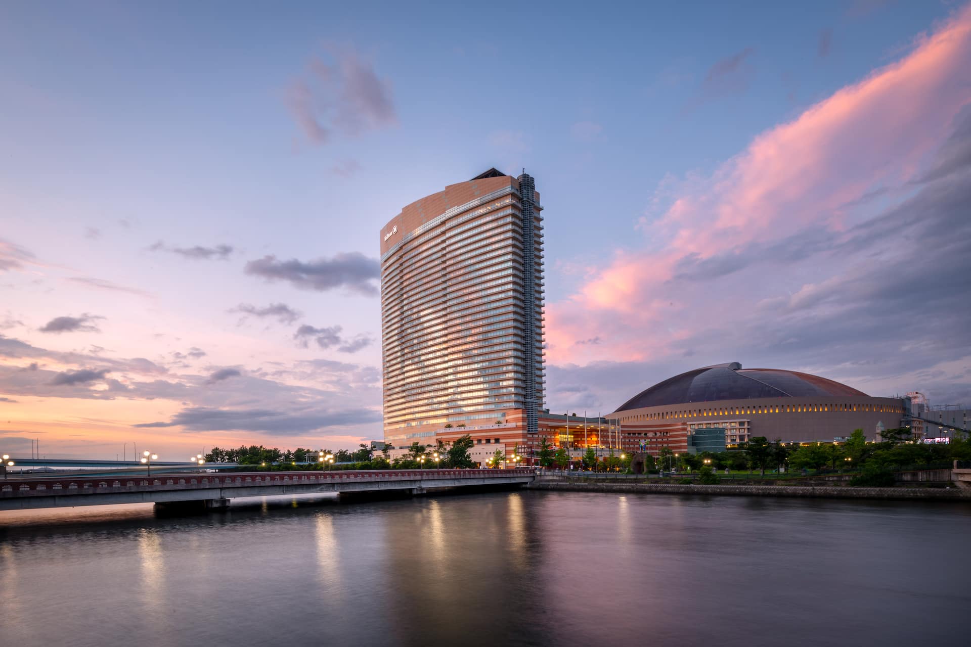 Hilton Fukuoka Sea Hawk exterior, the 35-floor sail-shaped tower seen from the Momochi waterfront with Hakata Bay in the background