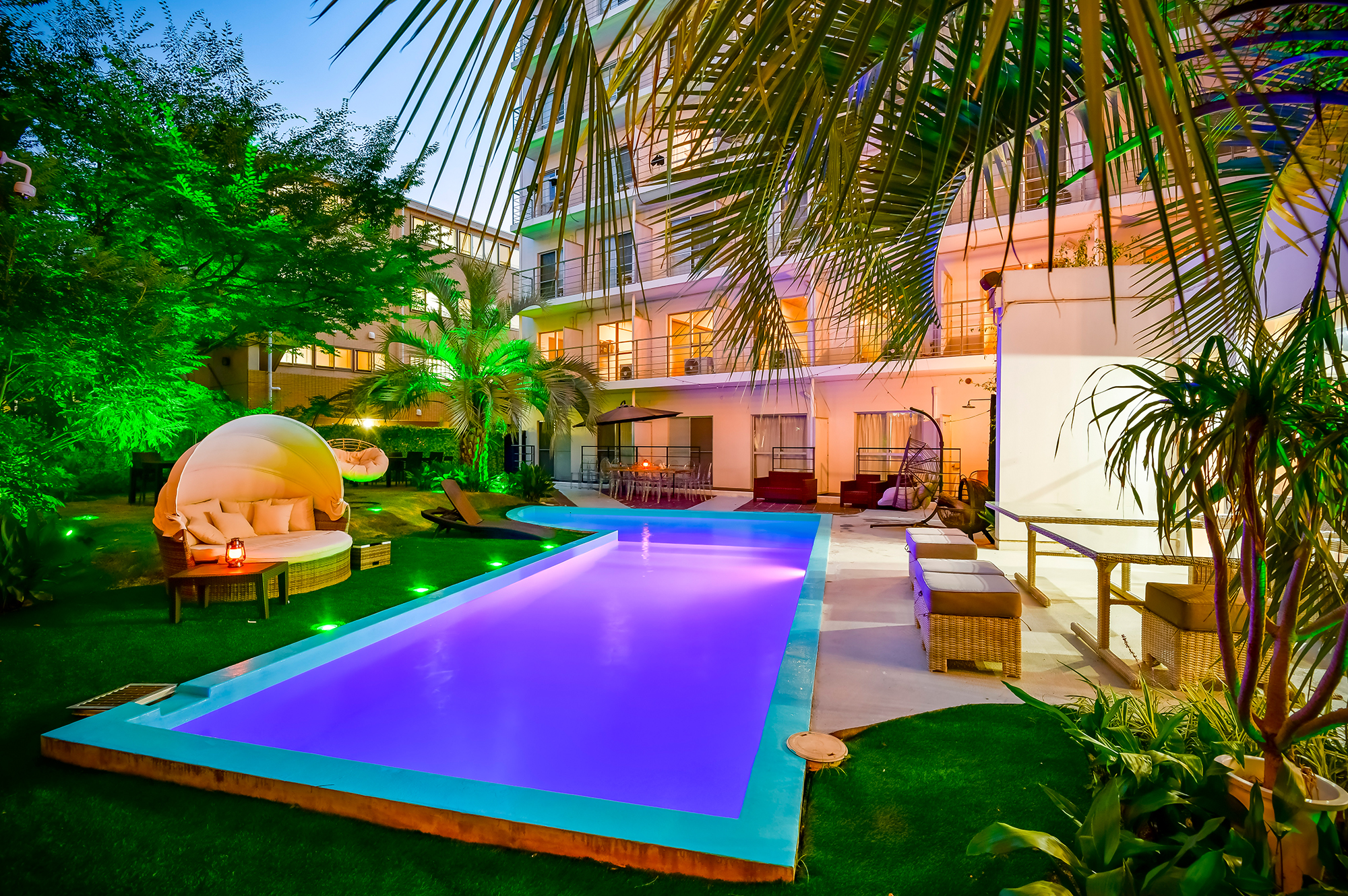 Hotel Japanesque Fukuoka poolside garden area with lounge pods and palms