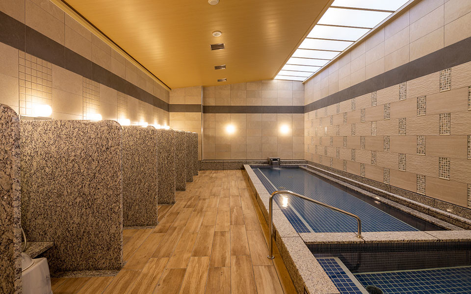 Hotel Monterey Fukuoka Trinite public bath — spacious soaking pool with granite wash stations