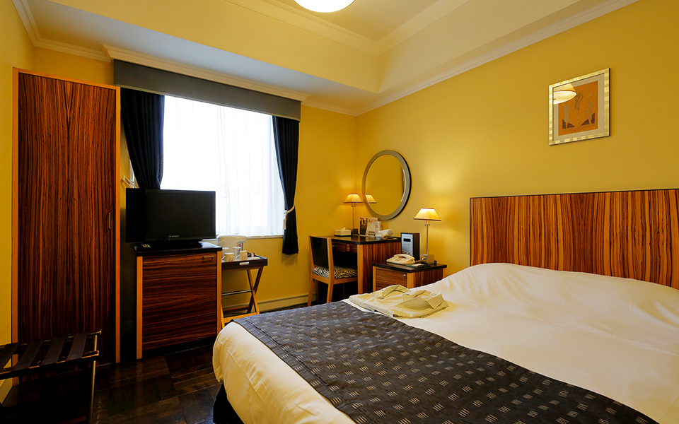 Semi-double room — compact solo traveler option with hardwood floors