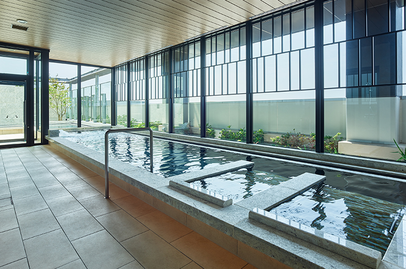13th-floor public bath at Mitsui Garden Hotel Fukuoka Gion showing the indoor bath and open-air outdoor terrace