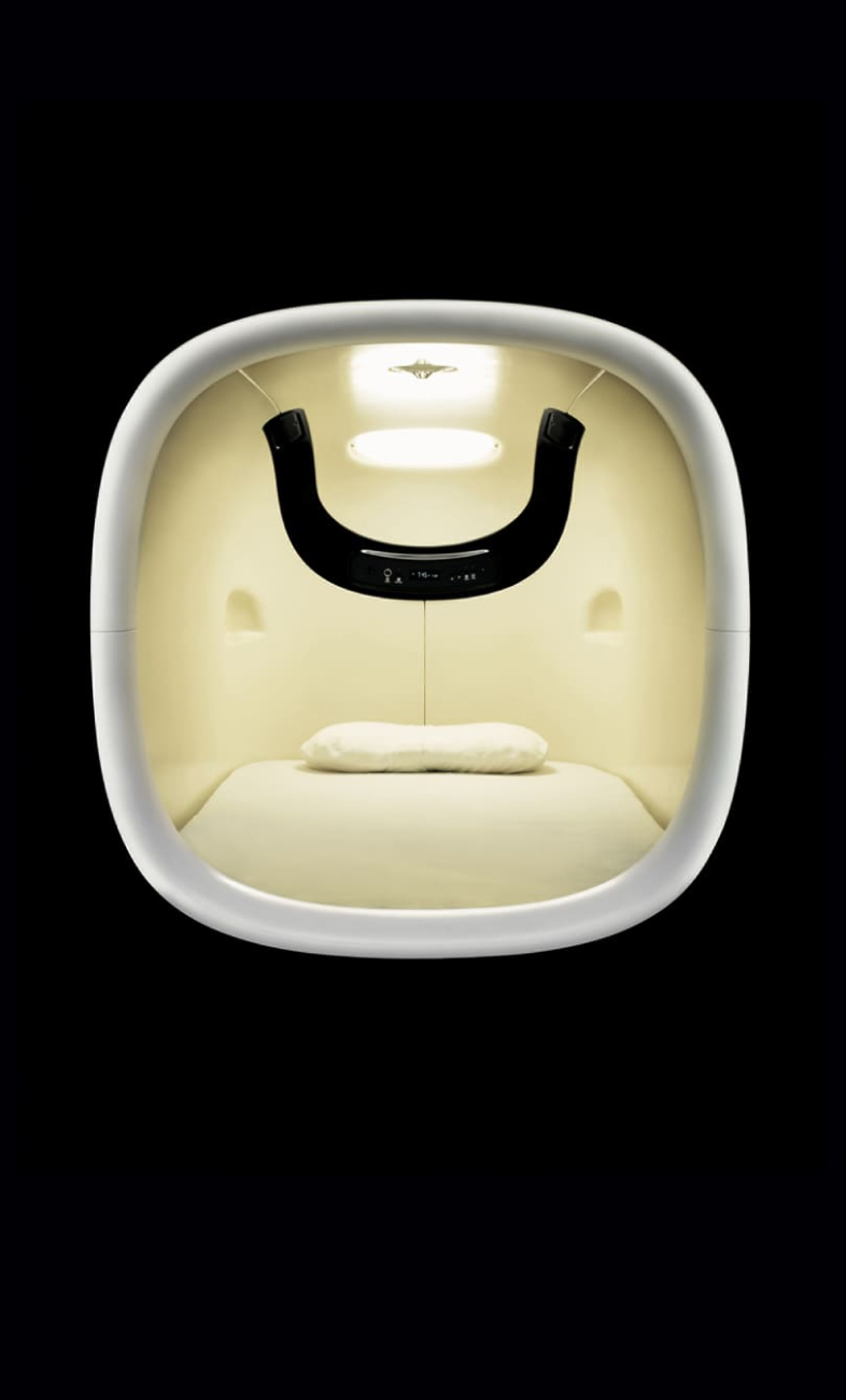 9h nine hours capsule pod interior close-up — TOTO Warm Pillar mattress surface and adjustable amber lighting panel
