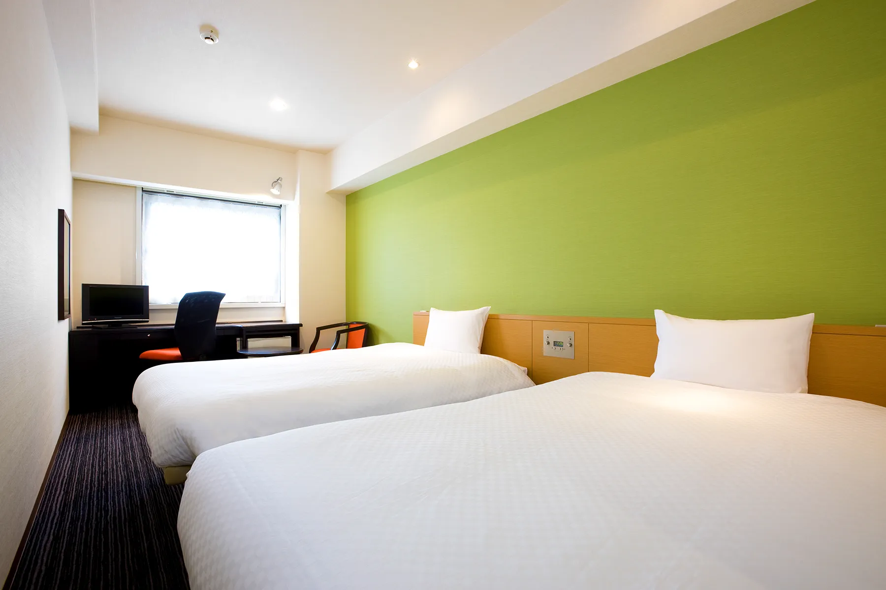 Deluxe Twin room (~22㎡) with two single beds and seating
