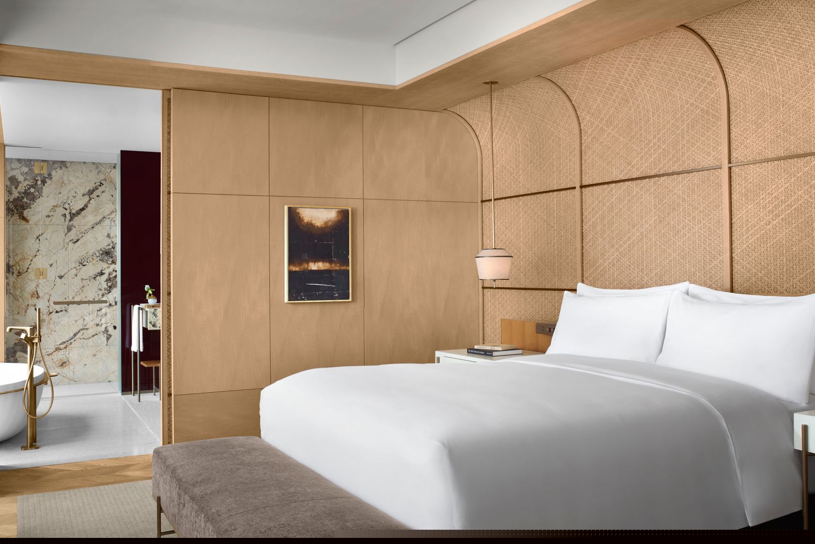 Ritz-Carlton Fukuoka suite bedroom with Hakata-ori textile headboard, king bed, and open marble bathroom beyond