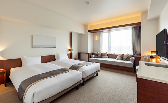 Twin room at Tokyu Stay Fukuoka Tenjin with large window and sofa seating area