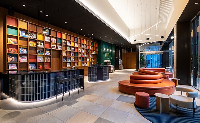 Tokyu Stay Hakata lobby with floor-to-ceiling bookshelves and curved front desk